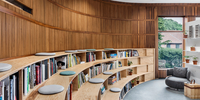 Mot den välvda väggen har man byggt en specialritad läktare som även fungerar som bokhylla. Foto: Kalle Sanner.
